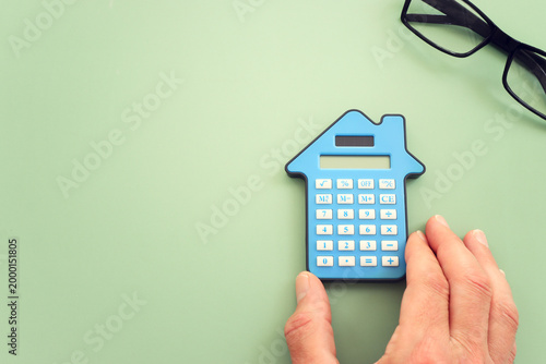 Calculator in the shape of a house. Idea of expenses and real estate