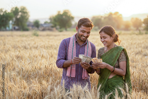 Happy Indian farmer couple counting money in wheat field at sunset, agriculture income and rural prosperity concept, smiling village lifestyle