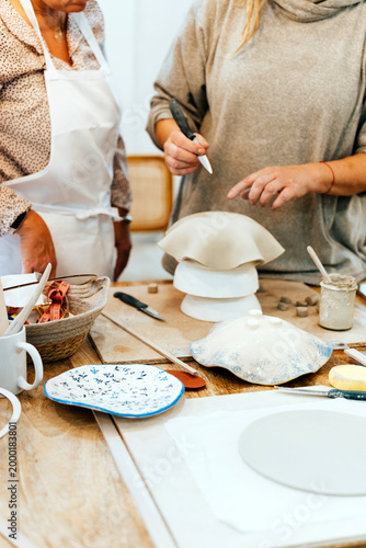 Slika na platnu People working with clay, shaping handmade ceramics in an artisan workshop