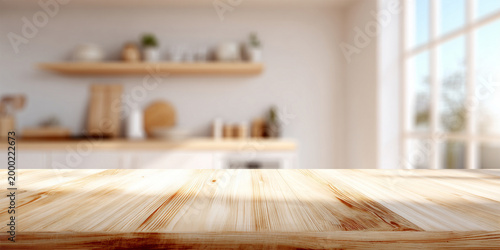 Sunlit wooden kitchen countertop with blurred modern interior background. Blurred kitchen on the background.