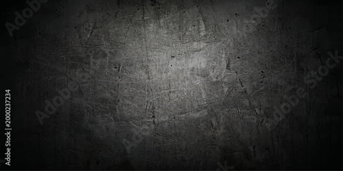 A dark grunge metal and concrete wall background featuring a rough textured stone surface with an aged vintage grey pattern and dirty black cement backdrop