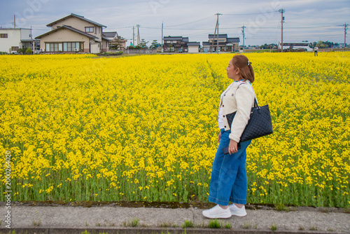 Woman Standing in a Field of Yellow Flowers