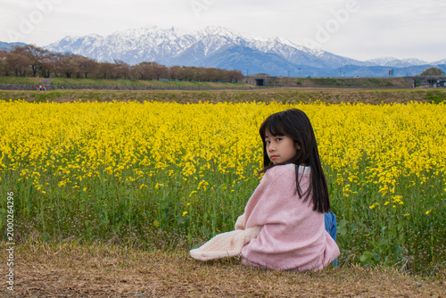 Girl in Yellow Flower Field with Mountains