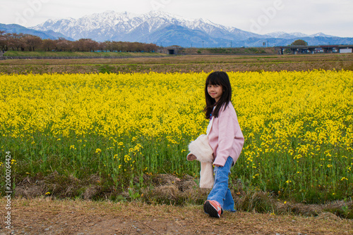 Girl in Yellow Flower Field with Mountains