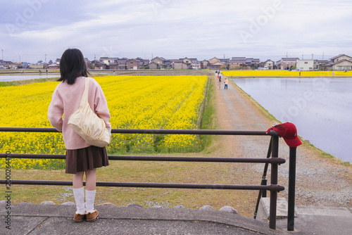 Girl in Pink Sweater by Yellow Flower Field