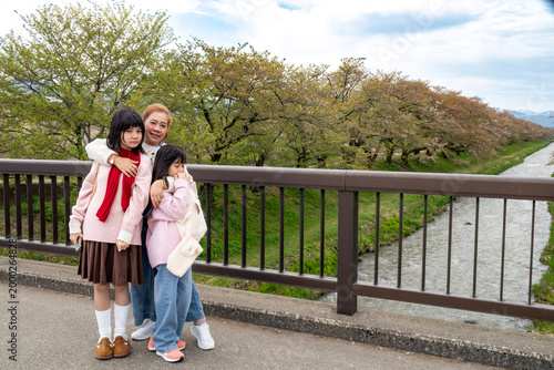 Family Posing by Cherry Blossoms and River