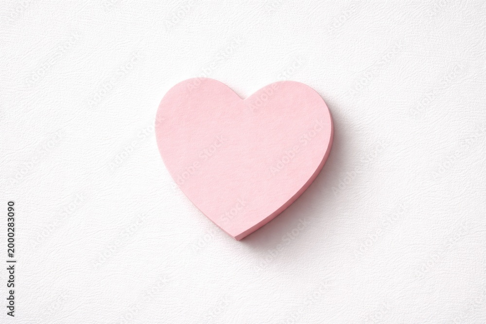 Fototapeta premium heart shaped sticky note placed on minimal white texture background with copy space