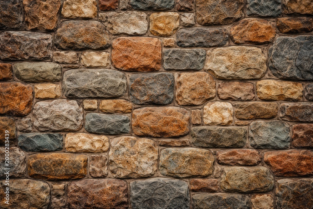 Fototapeta premium Background featuring rustic textured stone wall with multiple shapes and rich color variations for design use