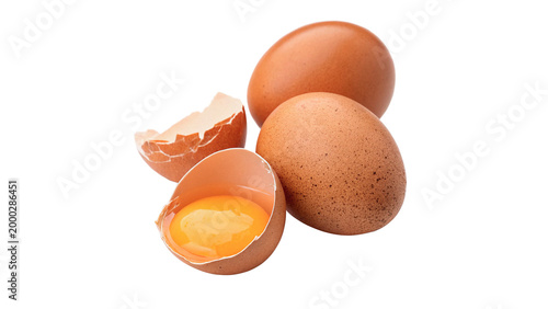 Brown eggs on a white background with one egg cracked open showing the yolk inside isolated on transparent background cut out