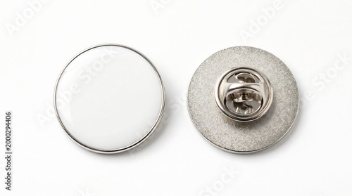 Two silver pin badges with white and textured backing shown from above on a white background