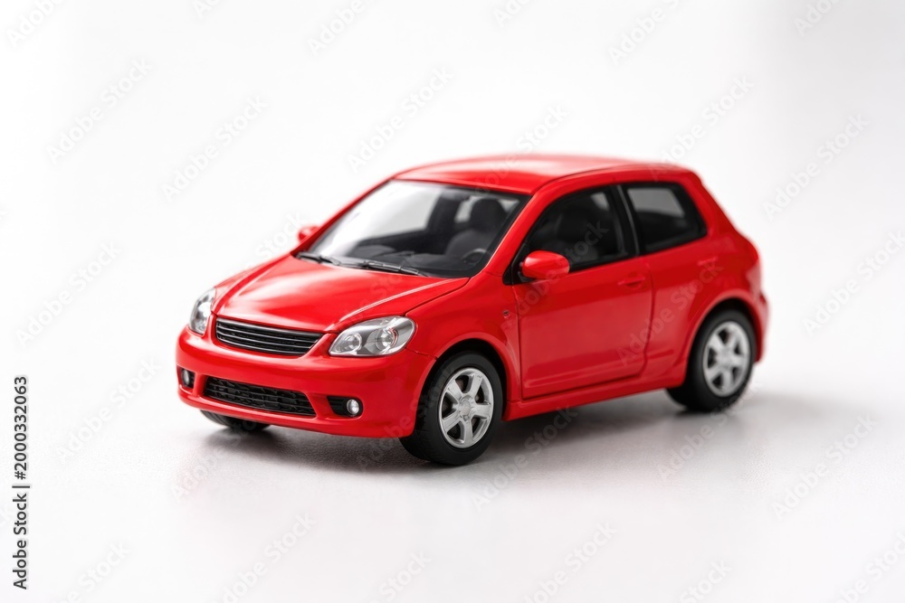 Obraz premium compact red toy car figure shown on an uncluttered white setting
