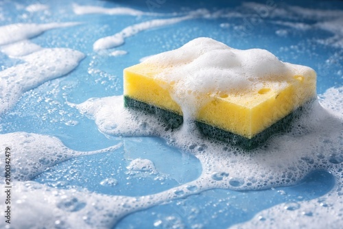 Blue surface background with foamy sponge and cleaning concept