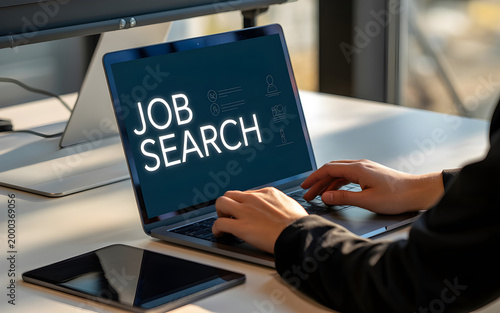 Job search concept hands typing on laptop with 'job search' displayed
