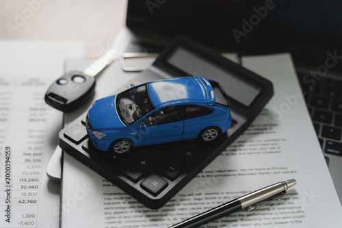 Cuadro en lienzo Blue toy car model on calculator with financial document showing numbers and key