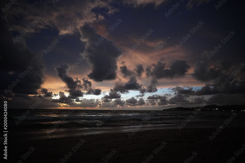 Fototapeta premium Dramatic twilight clouds over a dark ocean shore