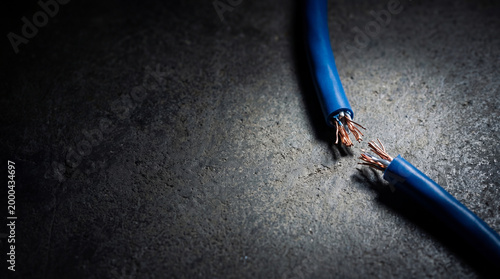 Cut blue internet cable on dark floor. Network disconnection and communication breakdown. Social media blocking and cyber security concept. Digital connection failure and internet censorship.