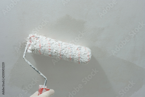 Paint roller in hand. Painting ceiling white paint