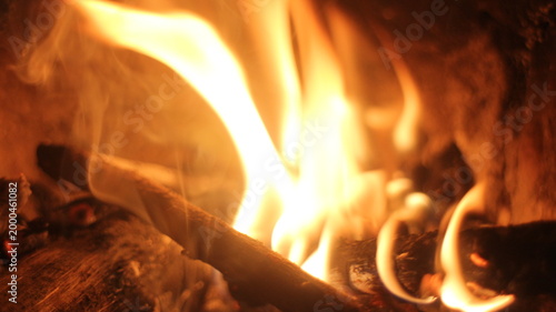 Home fireplace with burning wood, blazing fire creates a warm and cozy atmosphere.