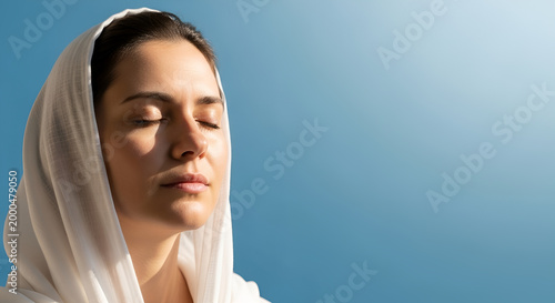 Muslim woman in white hijab praying with closed eyes under clear blue sky, spiritual meditation, peaceful religious portrait, faith and serenity, modest fashion