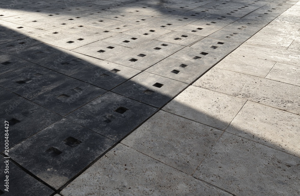 Fototapeta premium Patterned ground with light and shadow on rough textured square and rectangular tiles