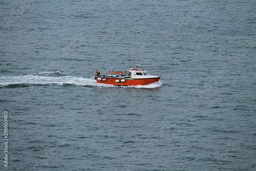 A Small Red and White Fishing Boat on the Open Sea.