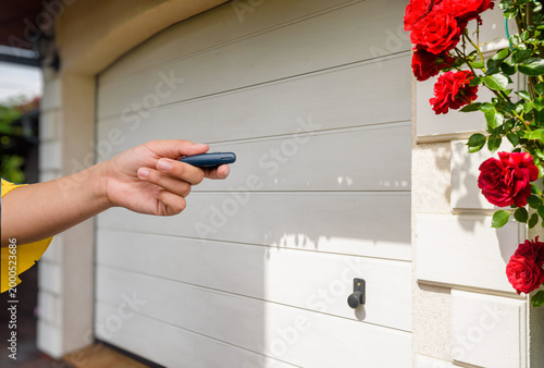 Garage door PVC. Hand use remote controller for closing and opening garage door
