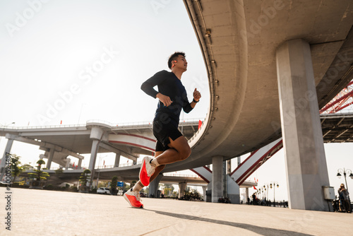 Dynamic Young Man Run Under Concrete Bridge Structure in Urban Landscape