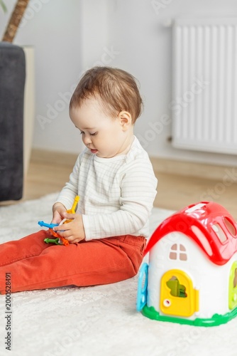 Toddler baby playing with educational toy at home, early childhood development and learning
