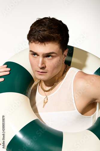 Εκτύπωση καμβά Handsome young man enjoys summer vibes with stylish lifebuoy in hand