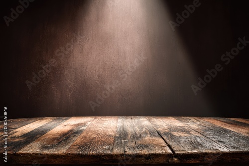 A rustic wooden tabletop is illuminated by a dramatic spotlight against a dark, textured backdrop.
