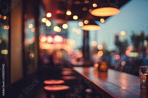 A blurred view from inside a bar showcases a warm, inviting atmosphere with bokeh lights and a partially visible counter.