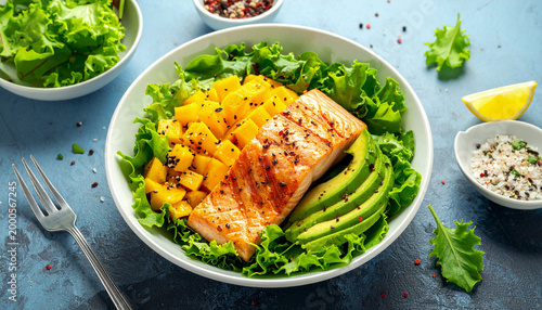 Grilled salmon and mango salad with avocado and fresh green lettuce