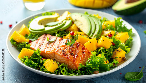 Grilled salmon and mango salad with avocado and fresh green lettuce