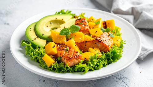 Grilled salmon and mango salad with avocado and fresh green lettuce