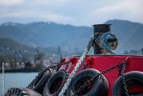 Tugboat Fenders and Bollard at Harbor with Mountains