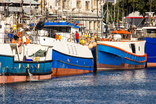 Quadro su tela Blue, red and white fishing boats docked at the harbour at the V&A waterfront in Cape Town, South Africa