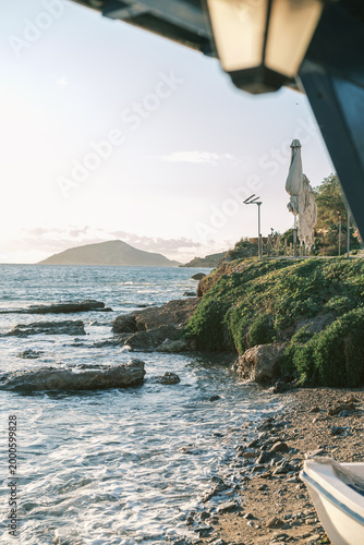Coastal landscape with calm sea and rocky shore at sunset