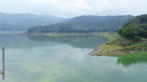 Panoramic view of a large lake nestled between verdant hills. Peaceful natural environment showcasing the beauty of a mountain watershed.