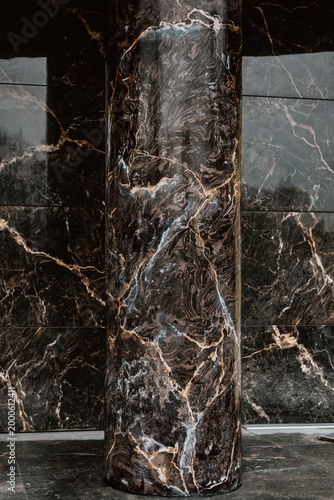 Classic luxury interior detail of modern hotel entrance with marble columns Massive marble pillar standing in interior hall expressing stability, durability, and monumental architectural presence