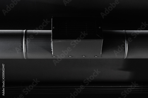 Black ceiling with air distribution and ventilation infrastructure, closeup photo Minimal black air duct installation highlighting modern engineering interior system