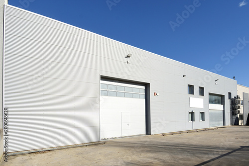 Modern gray warehouse with sheet metal cladding and large door