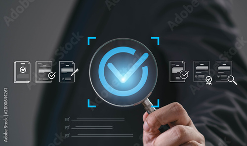 Businessman hold magnifying glass with approval checkmark and document icons representing quality control, compliance verification, audit process, document validation, corporate governance management.