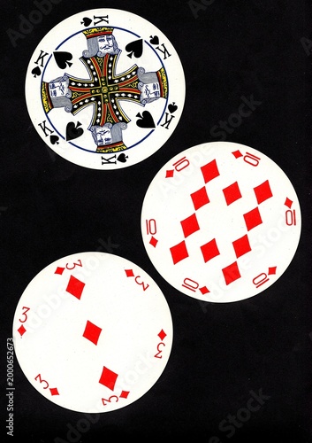 A hand of three vintage round playing cards isolated on a black background.