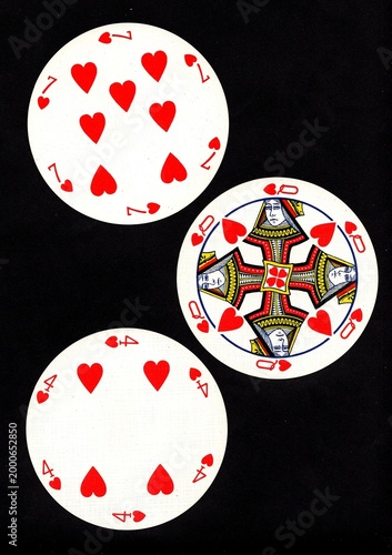 A hand of three vintage round playing cards isolated on a black background.