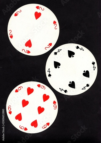 A hand of three vintage round playing cards isolated on a black background.