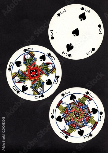 A hand of three vintage round playing cards isolated on a black background.