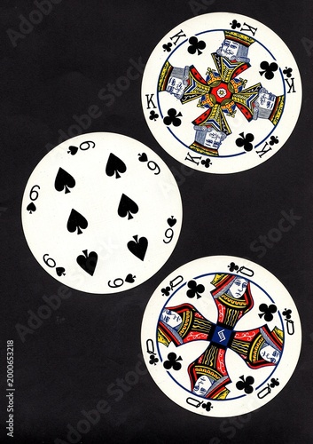 A hand of three vintage round playing cards isolated on a black background.