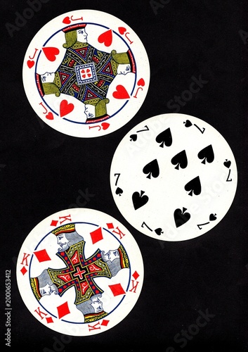 A hand of three vintage round playing cards isolated on a black background.