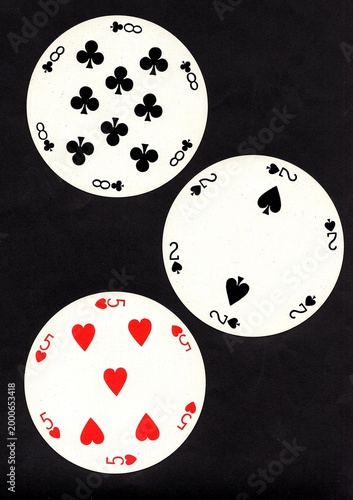 A hand of three vintage round playing cards isolated on a black background.