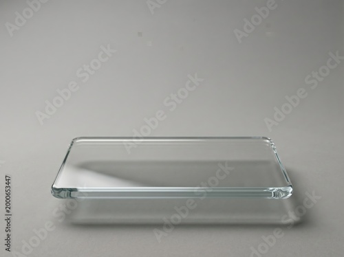 Rectangular clear glass panel floating with soft shadow and subtle reflection on neutral background for product display and composition
